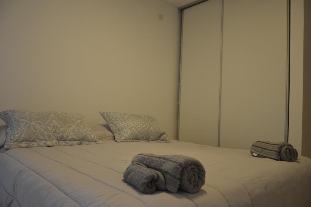 a bed with two towels on top of it at Espacio Aristobulo in Comodoro Rivadavia