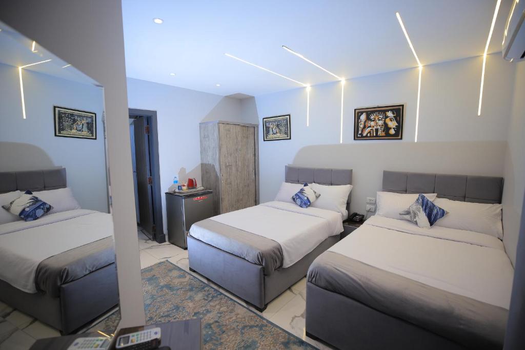 Postel nebo postele na pokoji v ubytování WOW Pyramids Inn With Rooftop Lounge