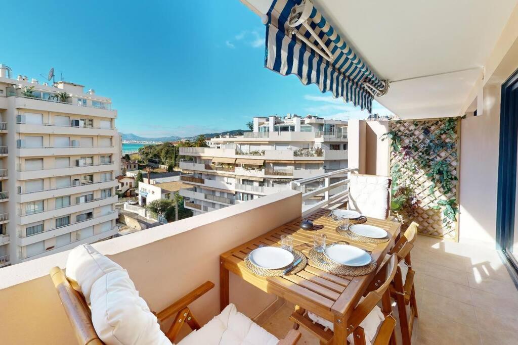 une salle à manger avec une table et des chaises sur un balcon dans l'établissement Terrasse avec aperçu mer, Piscine, Plage à 200m, à Cannes