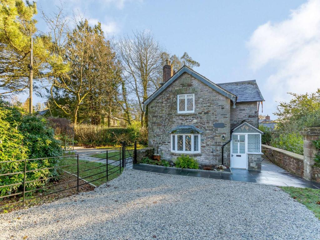 a stone house with a gate and a driveway at 2 Bed in Launceston 84660 in Tresmeer