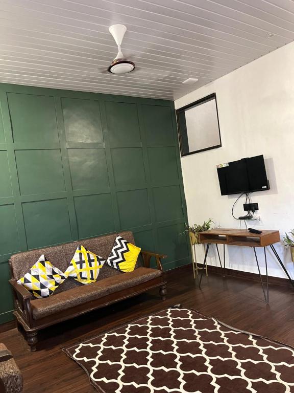 - un salon avec un canapé et une télévision dans l'établissement CANVAS VILLA & RESORT - LONAVALA, à Lonavala
