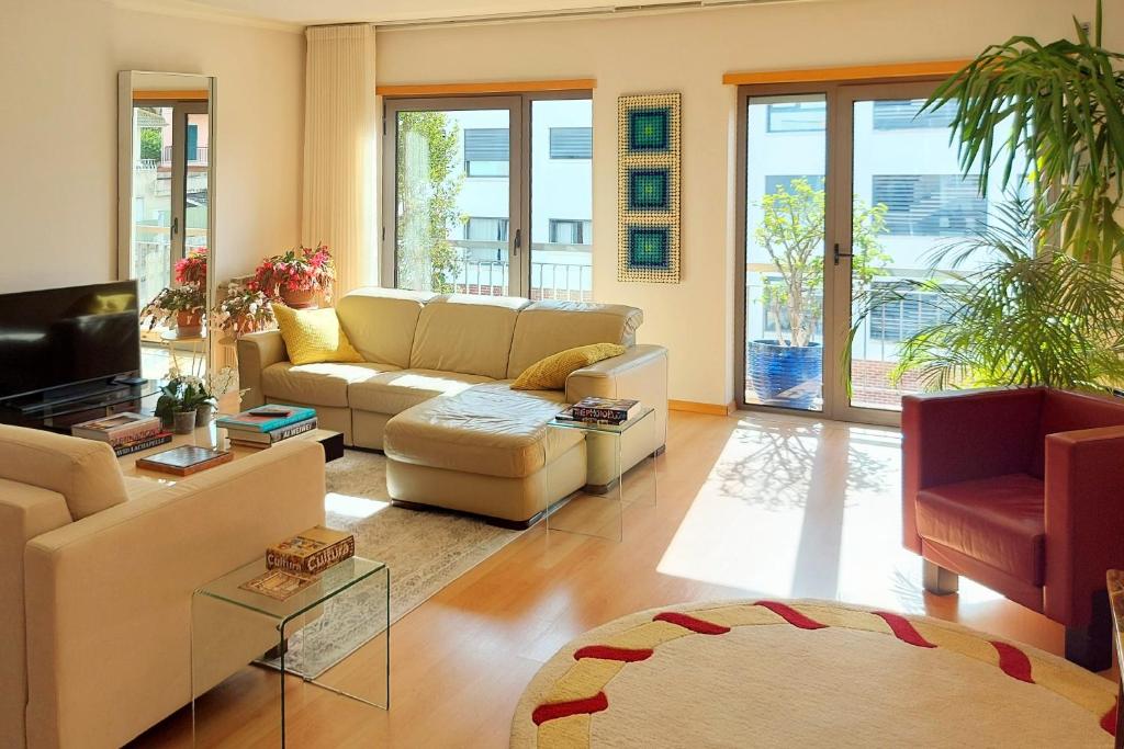 - un salon avec un canapé et une télévision dans l'établissement Sunny Flat Lisbon Oeiras, à Quejas