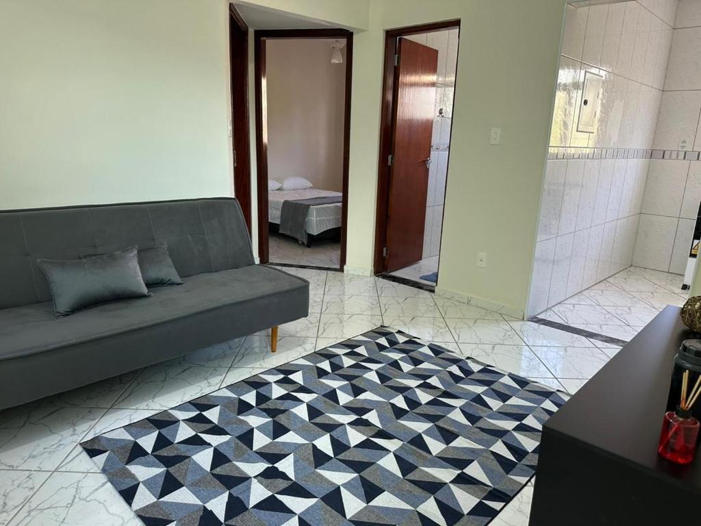 een woonkamer met een bank en een tapijt bij Apartamento Bem Localizado in Serra Negra