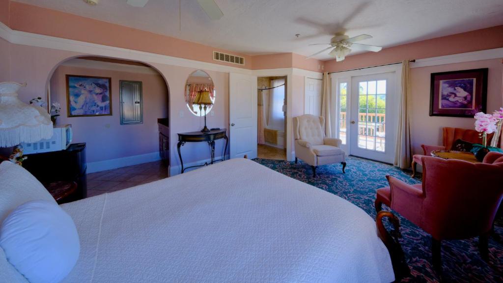 Un dormitorio con una cama blanca y una sala de estar. en Shorelight Inn, en Benicia