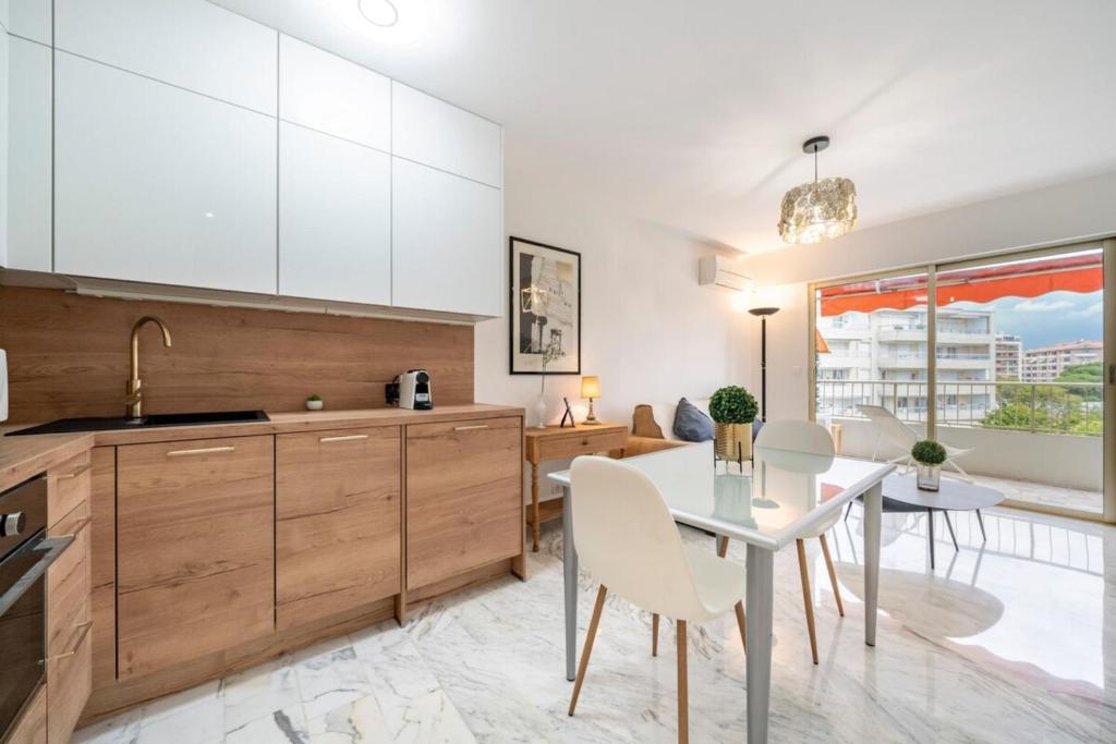 une cuisine et une salle à manger avec une table et des chaises dans l'établissement Lovely & bright one-bedroom close to the Croisette, à Cannes