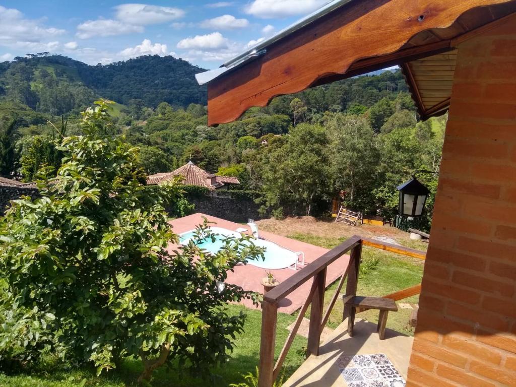 uma vista a partir da varanda de uma casa com piscina em Da Terra Brasil, Piscina e banheira dupla em Santo Antônio do Pinhal