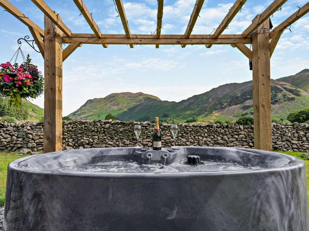 einen Whirlpool in einem Hof mit Bergen im Hintergrund in der Unterkunft 1 bed in Patterdale 85532 in Deepdale