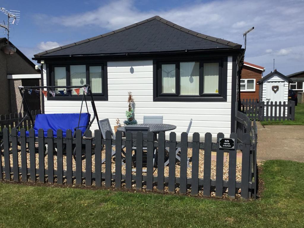 une petite maison avec une clôture devant elle dans l'établissement 88 southshore holiday village, à Bridlington