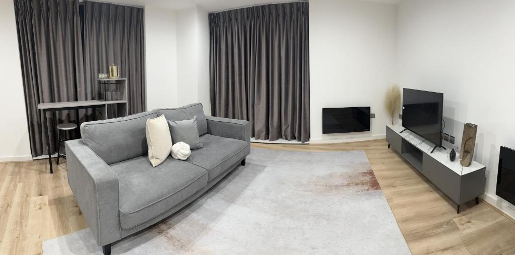 uma sala de estar com um sofá e uma televisão em Luxury 2 Bedroom Apartment Located In Birmingham City Centre em Birmingham