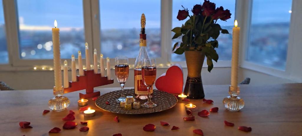 een tafel met kaarsen en bloemen en een vaas met rozen bij Apartament 3 camere Palas in Iaşi