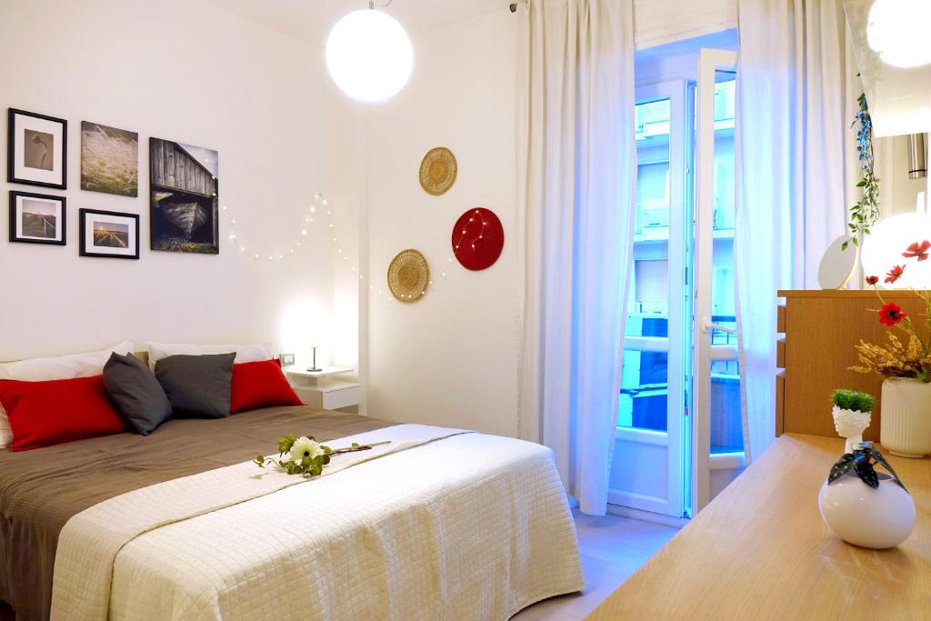 ein Schlafzimmer mit einem großen Bett mit roten Kissen in der Unterkunft Metro Bengasi Torino Lingotto Premium location - eXpress traveler spazioso - Grand Maison in Turin