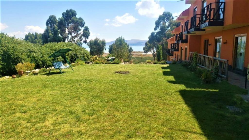un gran patio con un banco en el césped en Hotel Pumakala, en Puno