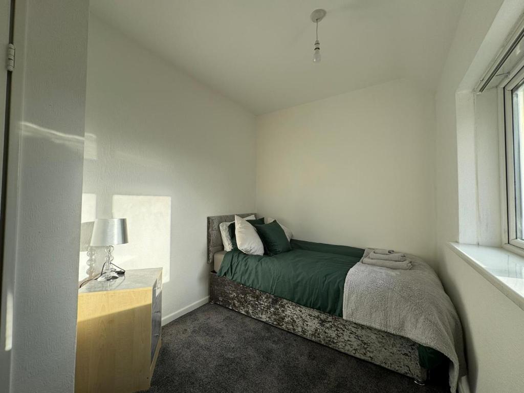 ein Schlafzimmer mit einem Bett, einer Kommode und einem Fenster in der Unterkunft Noormak nights in Birmingham