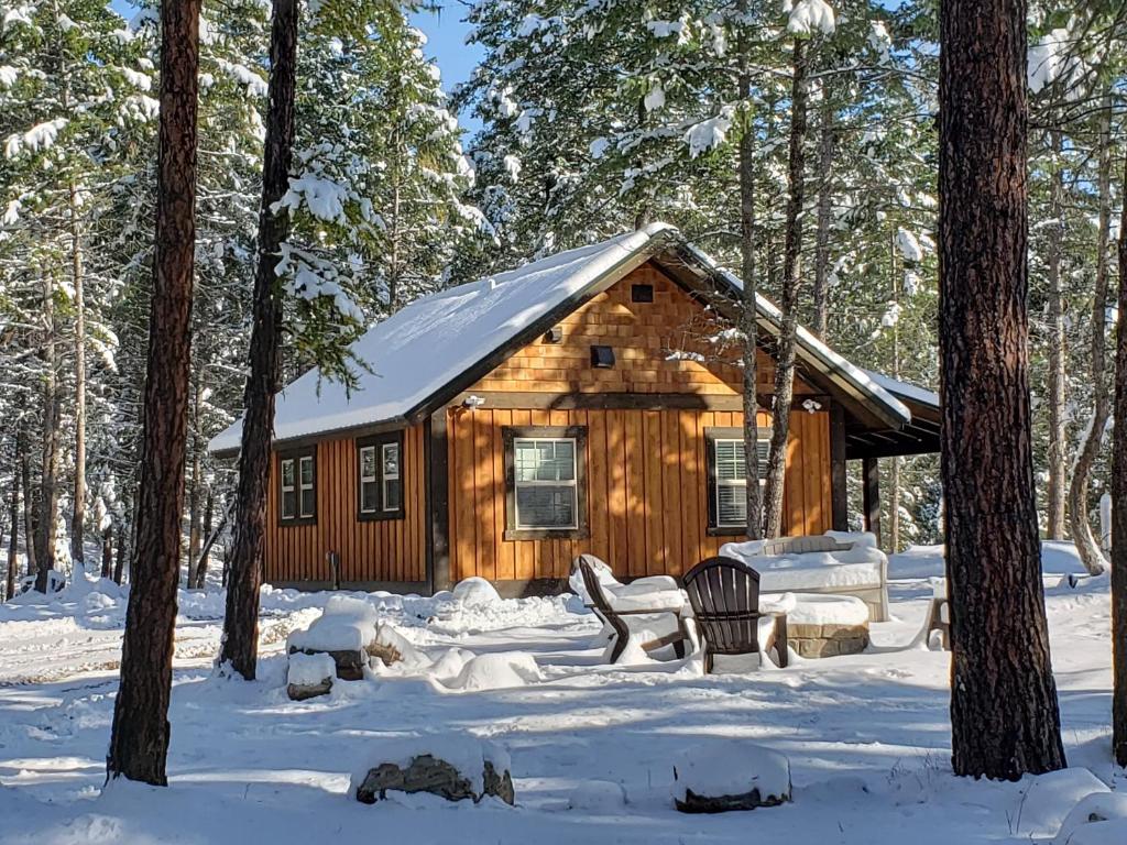 eine Hütte im Wald im Schnee in der Unterkunft Whispering Pines cabins in Lakeside