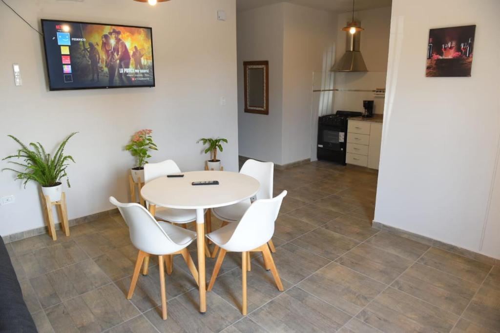 a dining room with a table and white chairs at Casa Malbec in San Martín