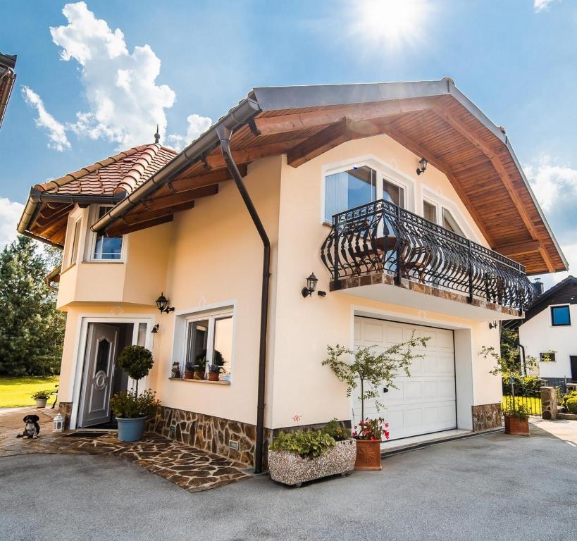 a house with a balcony and a garage at Apartment Joga in Rečica ob Savinji