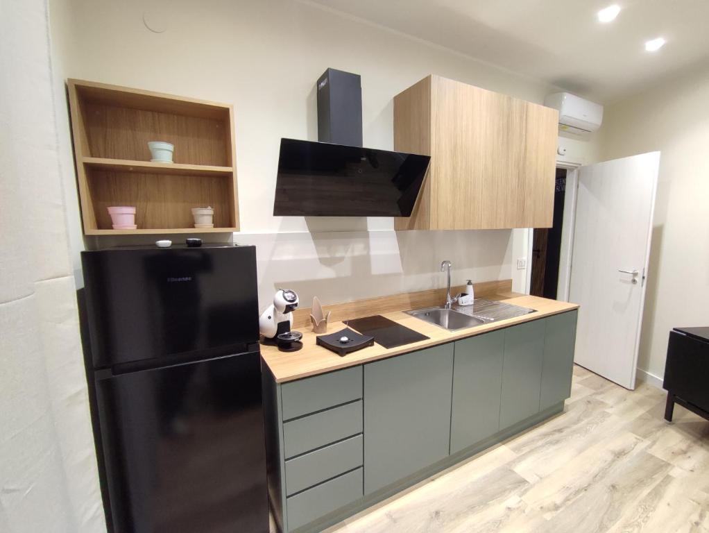 a kitchen with a black refrigerator and a sink at Nalí Guest House in Ercolano