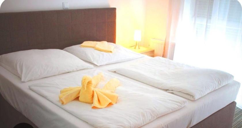 a white bed with two yellow towels on it at Hotel Zur Bahnhof in Crailsheim