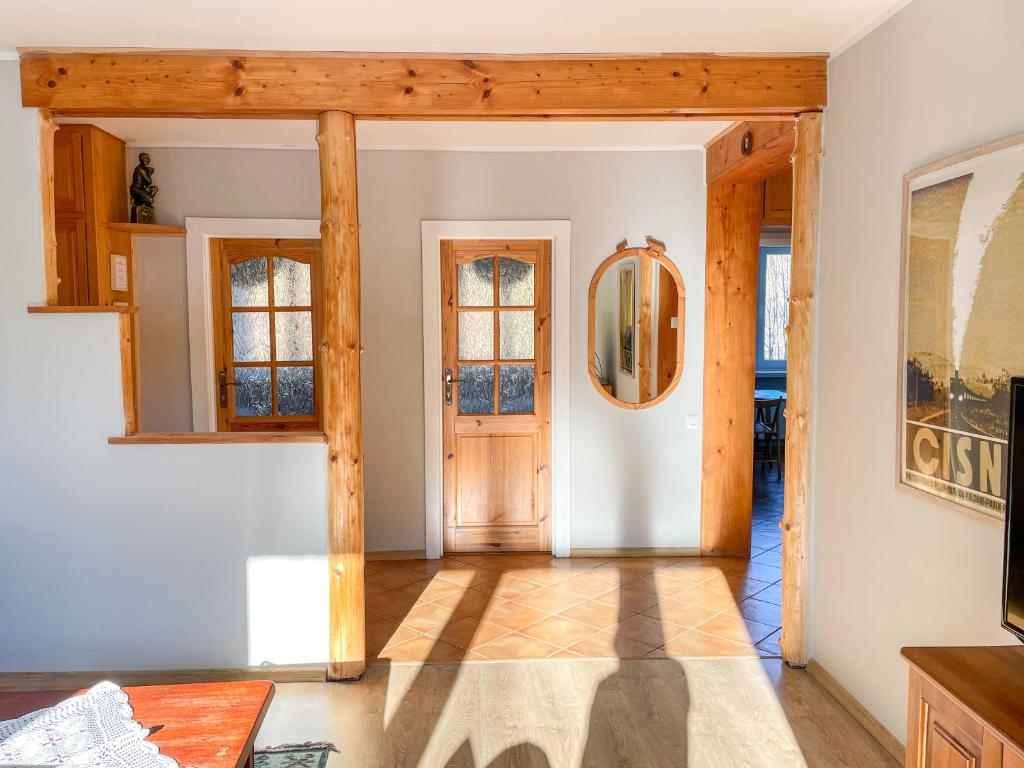 a living room with a wooden door and windows at Między górami. Apartament w Cisnej in Cisna