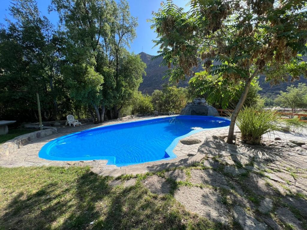 una piscina en un patio con un árbol en Cabañas La Calchona, en Melocotón