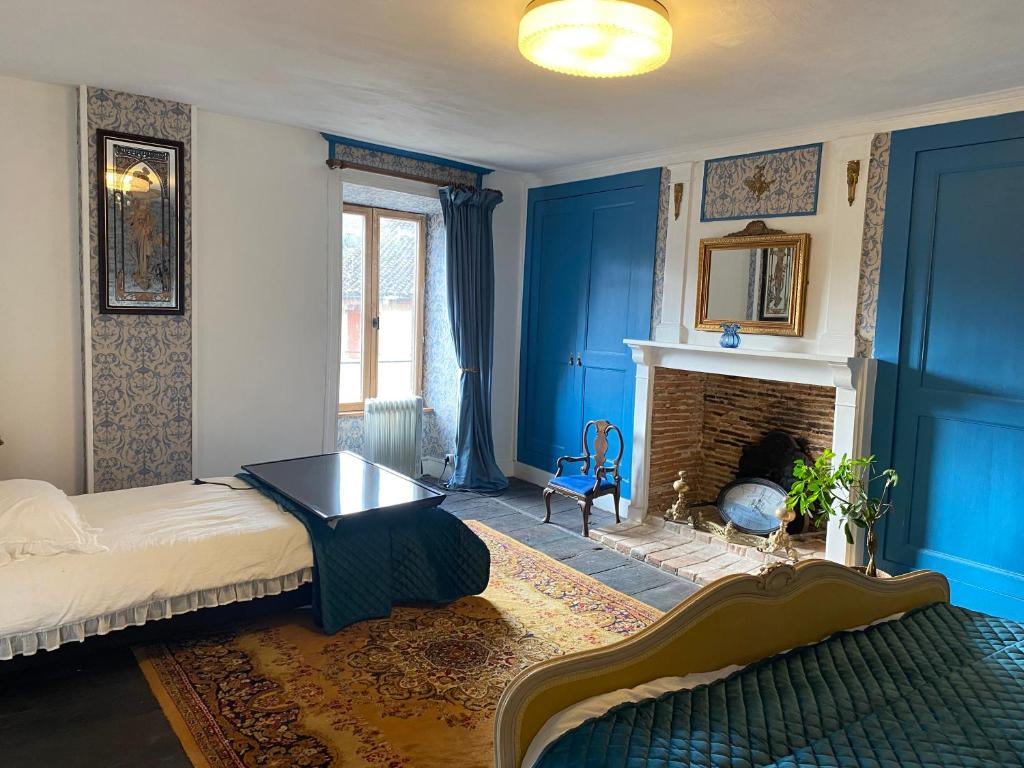 Habitación azul con cama y chimenea en Moon River Bellac Chambre d'hotes, en Bellac