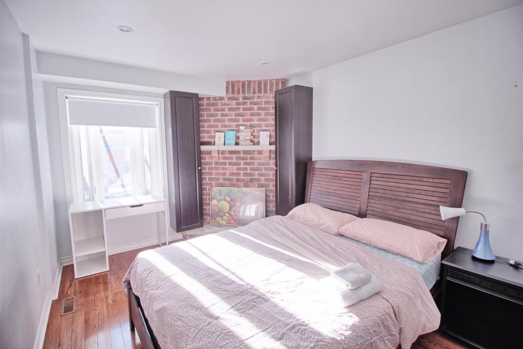 um quarto com uma cama e uma parede de tijolos em Beautiful room with private powder room em Vaughan