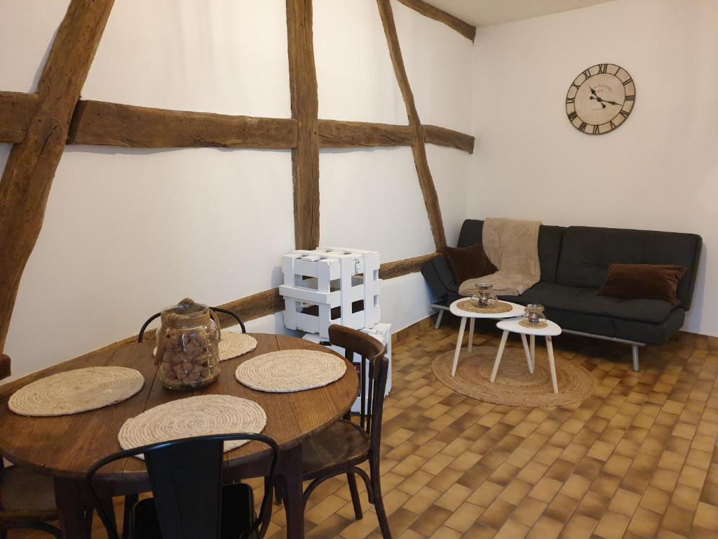 a living room with a table and a couch at Appartement au cœur du Berry in Lignières