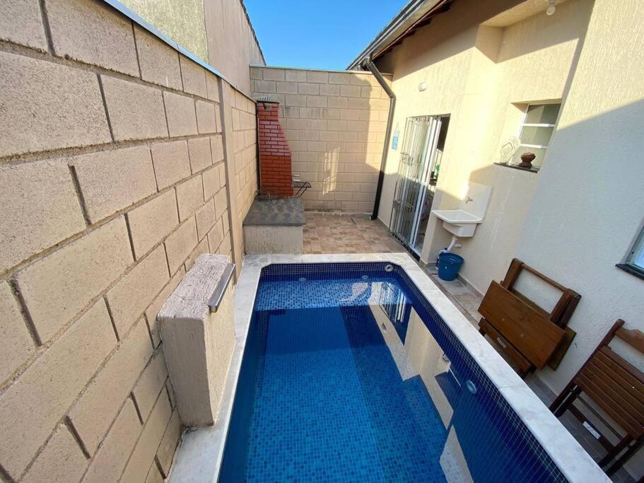 une petite piscine devant un immeuble dans l'établissement Casa de cond com piscina e churrasqueira particular, à Itanhaém