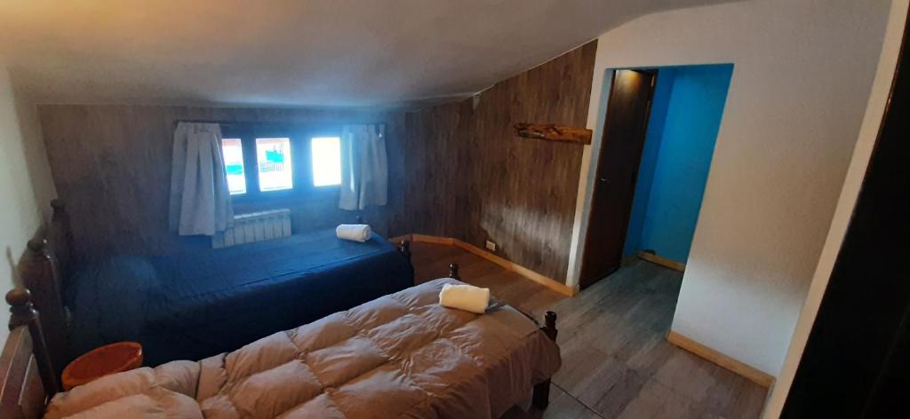 a bedroom with a bed in a room with a window at Posada Copahue in San Carlos de Bariloche