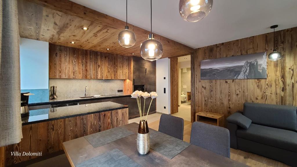 eine Küche und ein Esszimmer mit einem Tisch und einem Sofa in der Unterkunft Villa Dolomiti in St. Ulrich in Gröden