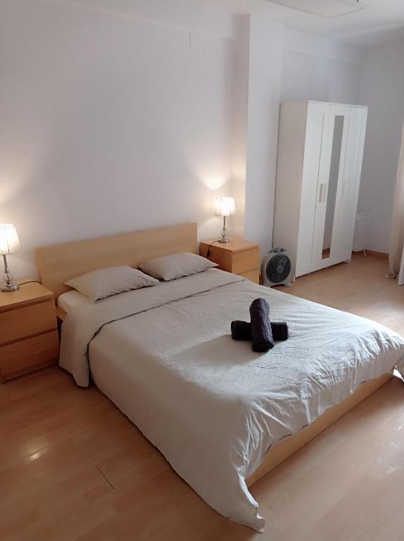 ein Schlafzimmer mit einem großen weißen Bett mit zwei Lampen in der Unterkunft Bright Private Double Room City Center Metro L-1 Urgell L-5 Hospital Clinic in Barcelona