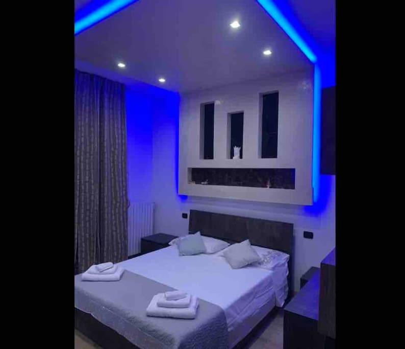 a bedroom with two beds with blue lighting at Appartamento Luxury Adri in Talignano