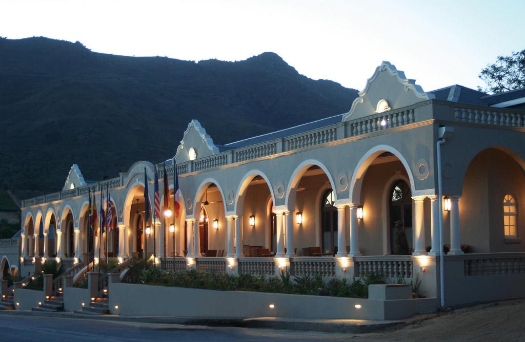 ein großes weißes Gebäude mit Beleuchtung in der Unterkunft The Royal Hotel in Riebeek-Kasteel