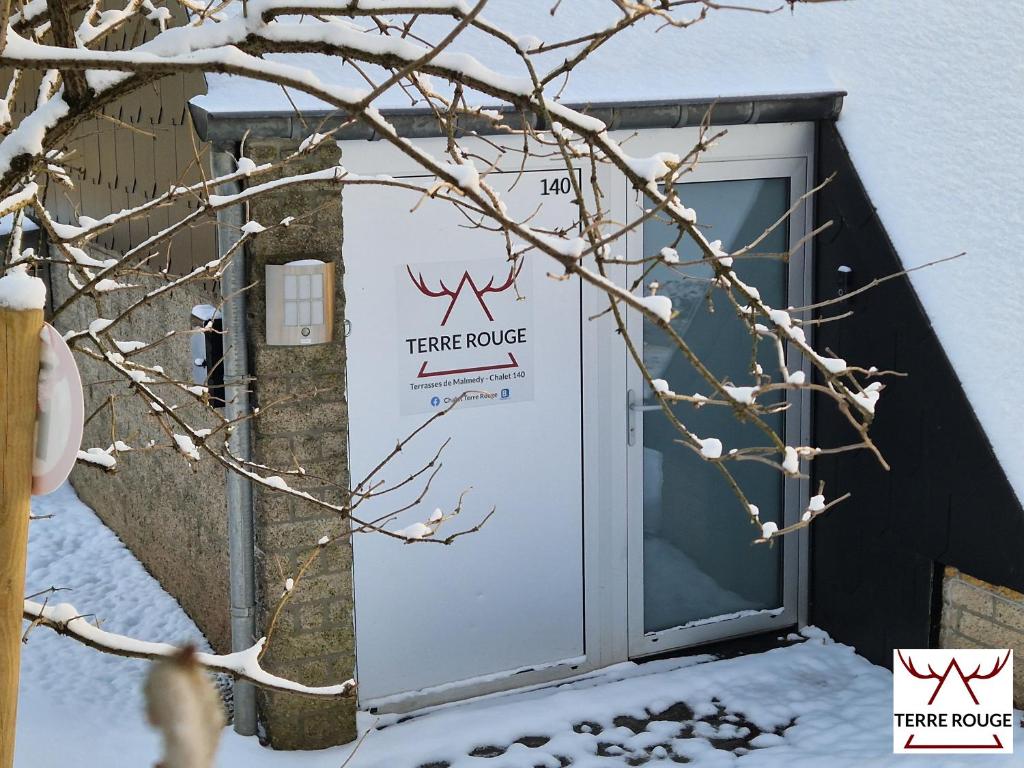 una puerta a una casa trampa en la nieve en Terre Rouge - Terra Rubica - Les Terrasses de Malmedy en Malmedy