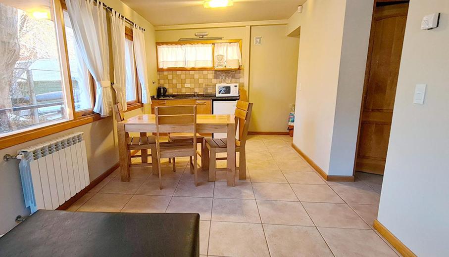 eine Küche mit einem Tisch und Stühlen im Zimmer in der Unterkunft Departamento Frente al Lago-San Martin de Los Andes in San Martín de los Andes