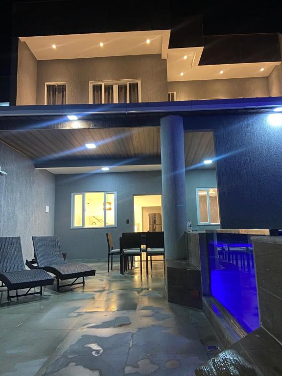 un salon avec une table, des chaises et une télévision dans l'établissement Casa linda em Unamar!, à Cabo Frio