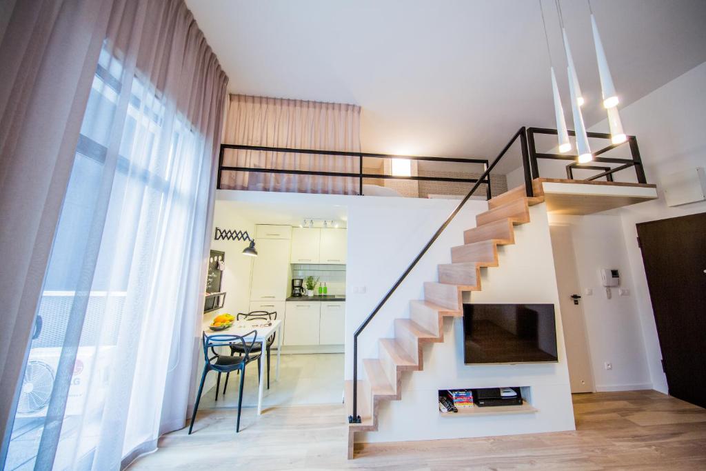 un salon avec un escalier et une salle à manger dans l'établissement Mojito Apartments – Botanica, à Wrocław