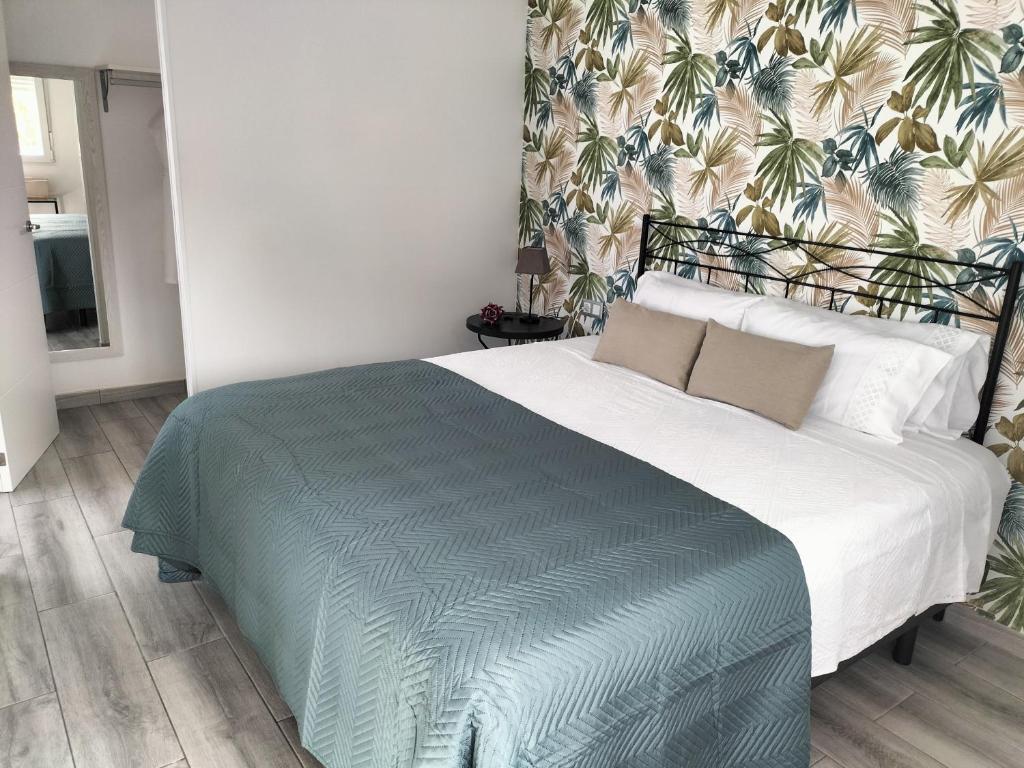 ein Schlafzimmer mit einem großen Bett und einer tropischen Tapete in der Unterkunft casa lipa in La Guancha