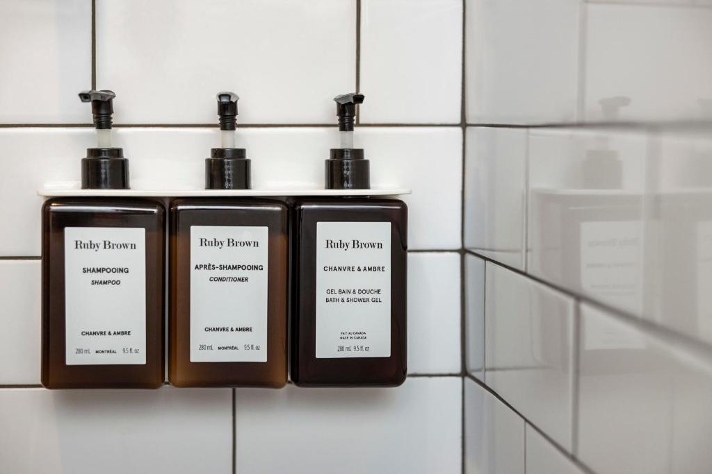 two bottles of laundry room products on a wall at Hôtel Le Germain Québec in Quebec City