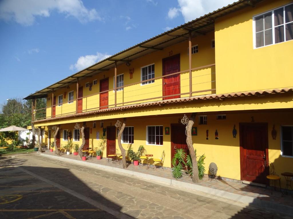 a yellow building with red doors on a street at Hostal Juarez Ataco in Concepción de Ataco