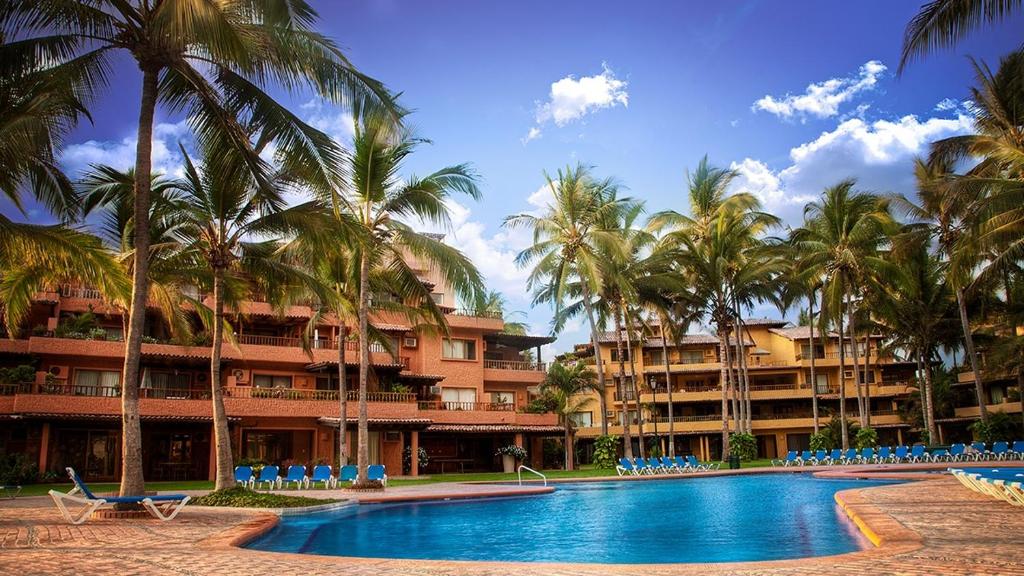 a resort with a swimming pool and palm trees at 15 - 139 B Stunning Oceanview Dept in Los Tules in Puerto Vallarta