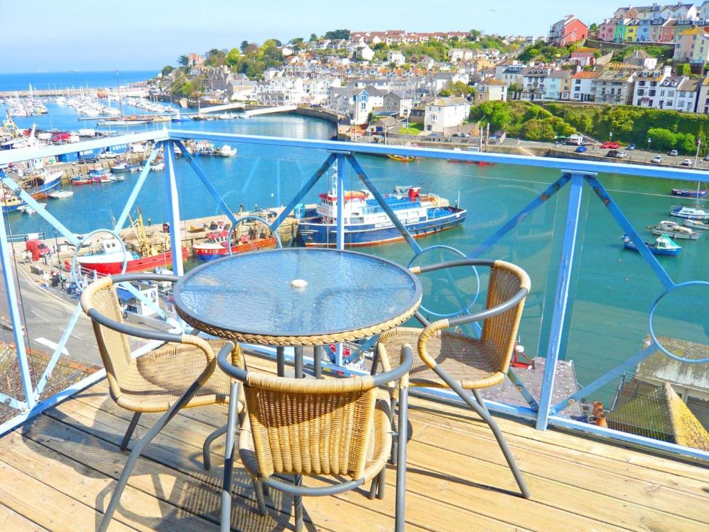 a table and chairs on a balcony with a harbor at 2 Bed in Brixham BX026 in Brixham