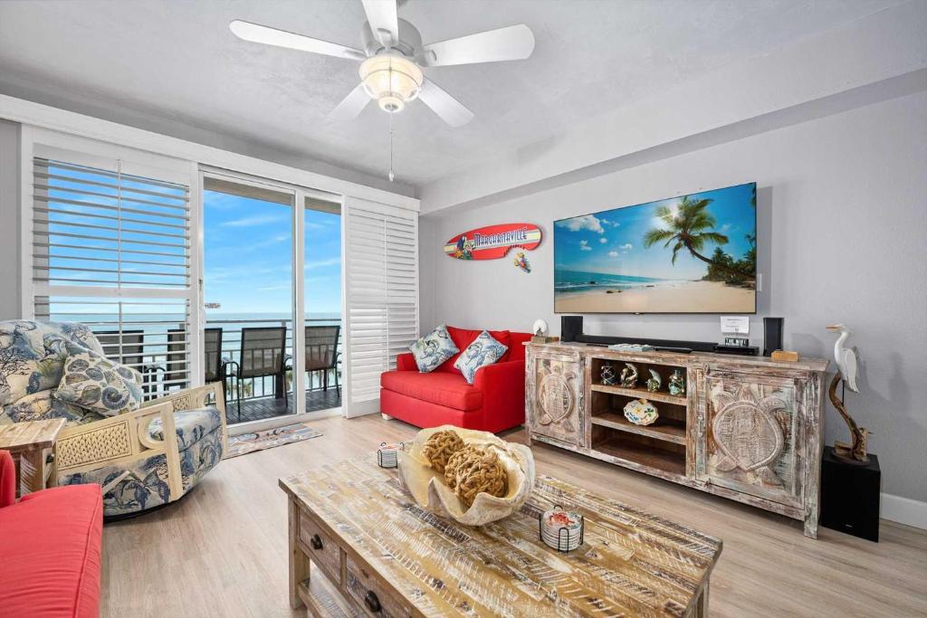 a living room with a red couch and a tv at Luxury Beach Villa Wyndham Ocean Walk Resort in Daytona Beach