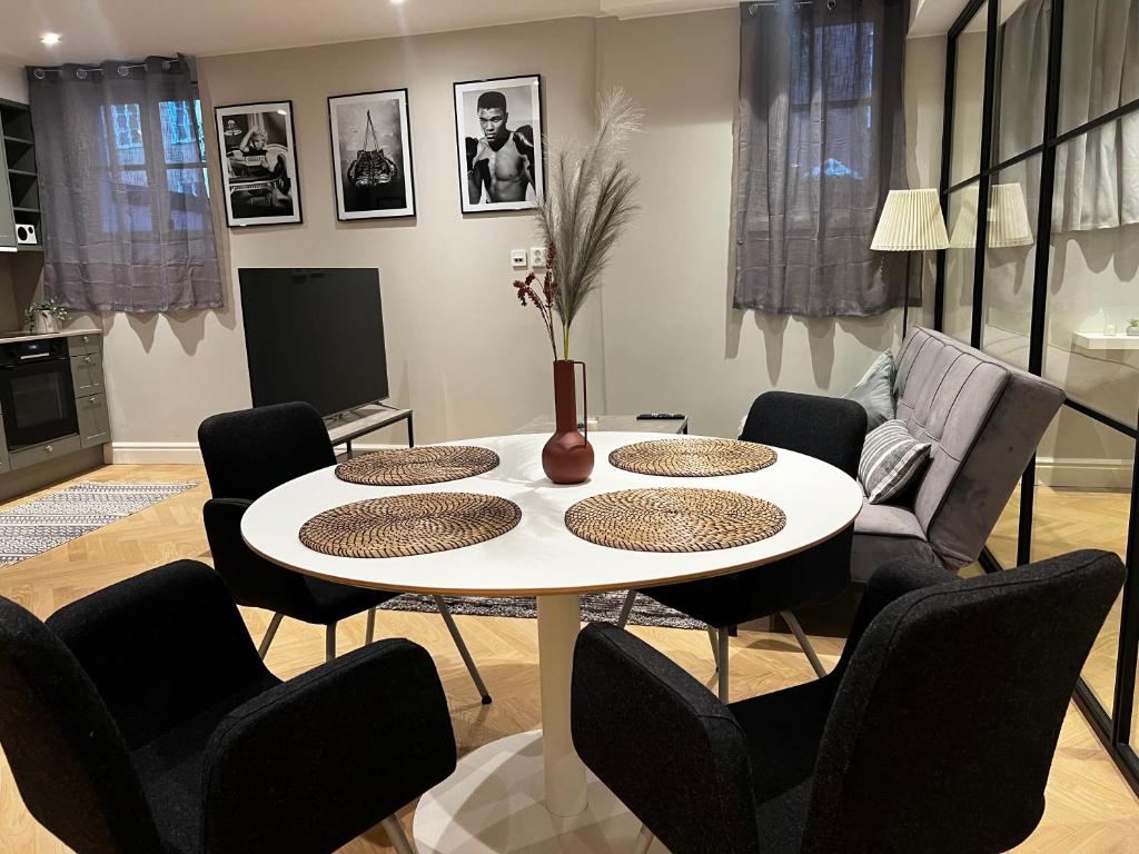 sala de estar con mesa blanca y sillas en Svea Deluxe Apartment en Estocolmo