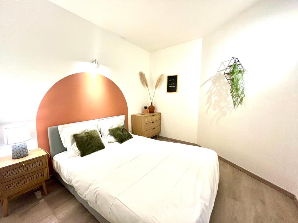 a bedroom with a large bed with an orange headboard at Le Mirror- hyper centre ville in Sens