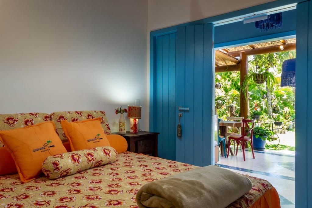 a bedroom with a bed and a blue door at Suite LIAM - Guest House Guaiu in Santa Cruz Cabrália