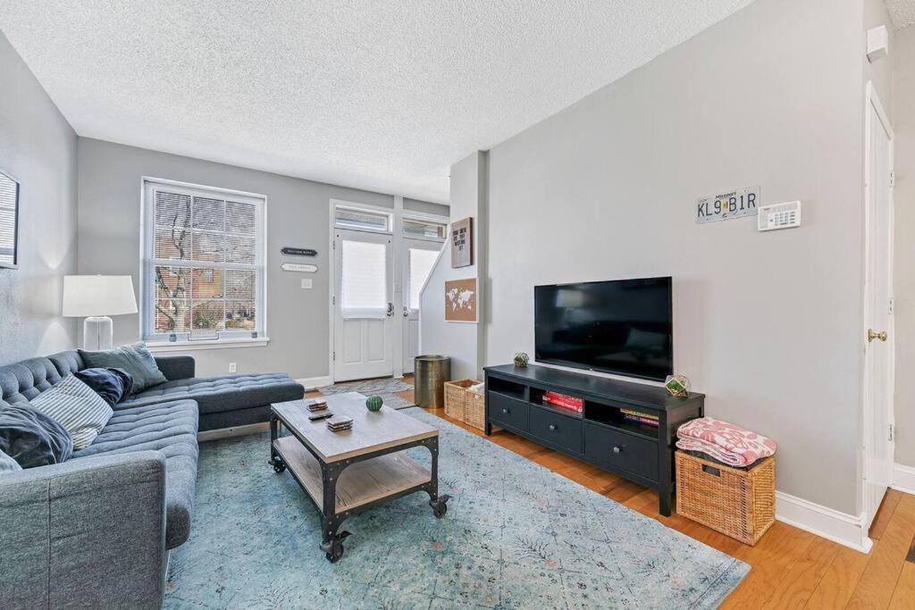 a living room with a couch and a tv at 3 King Beds/3Baths Spacious in Soulard