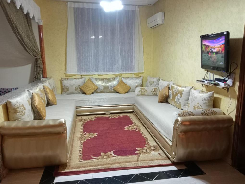 a living room with a couch and a television at Maison a louer par jour pour familles in Meknès