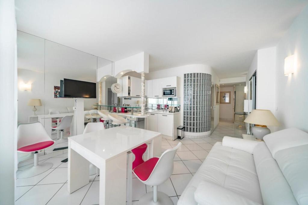un salon blanc avec un canapé blanc et une table dans l'établissement Nice 2-3 bedroom ideally located, à Cannes