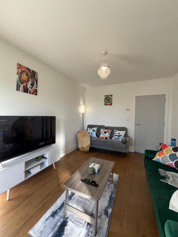 a living room with a couch and a tv at New Peaceful Luxury Home with free ParkingWiFi Sheffield in Sheffield